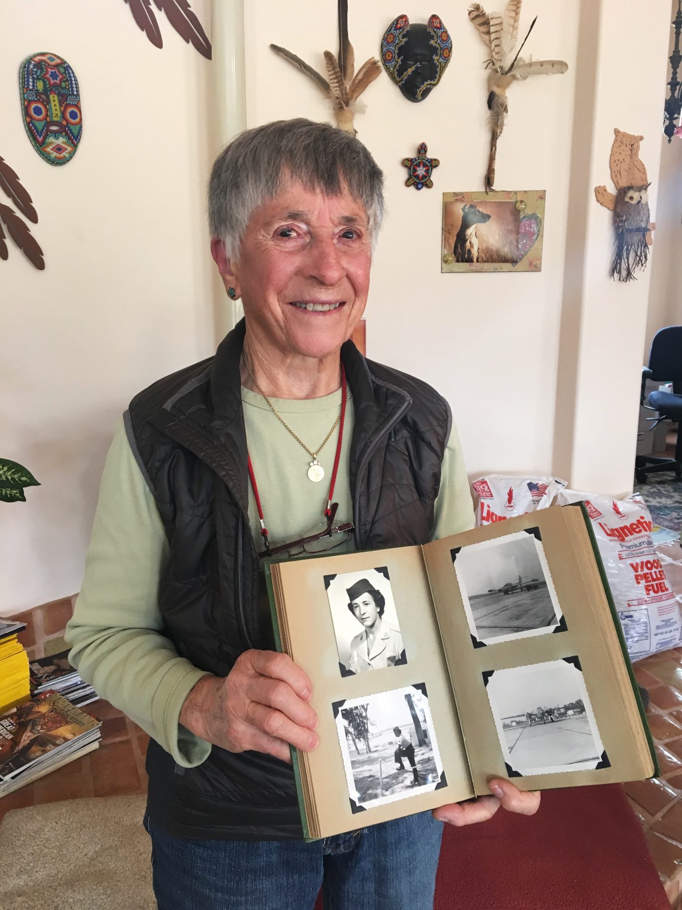 Legal Aid at Work client Helen James holding up a photo album of her time in the military