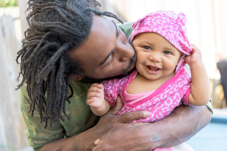 African american man posing posing holding his baby daughter