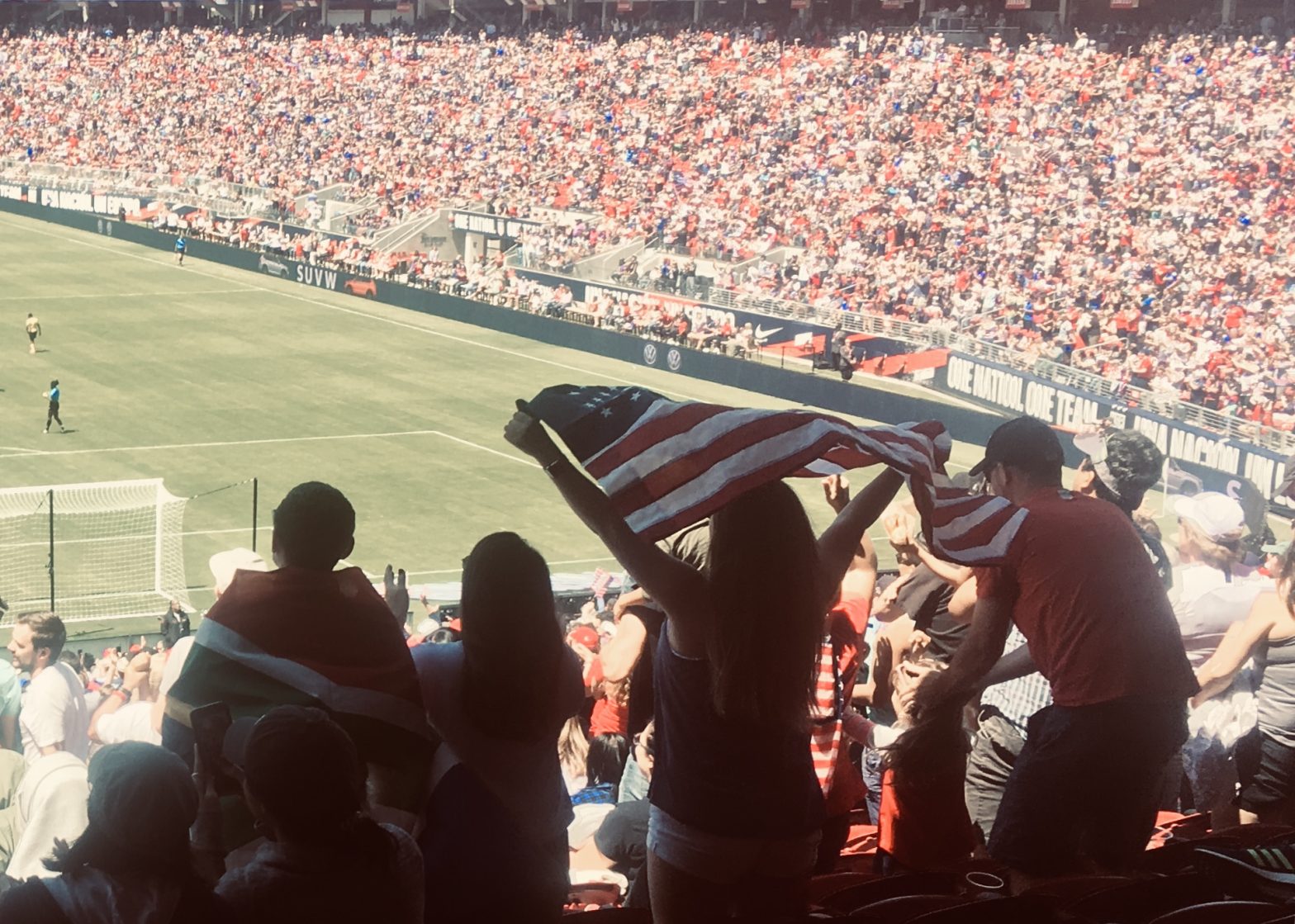 Crowd holding up U.S. flags during a soccer match