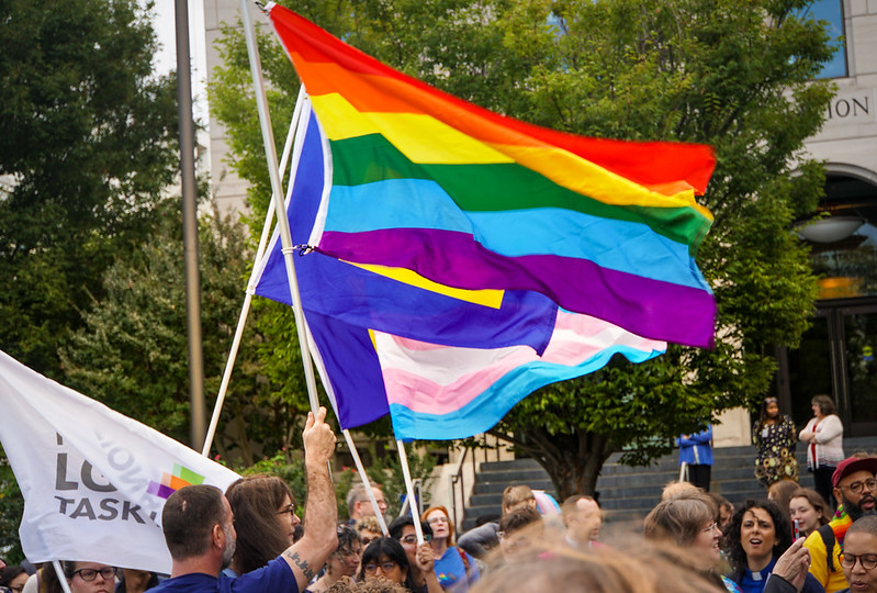 People holding up Pride, Human Rights Campaign, and Transgender flags