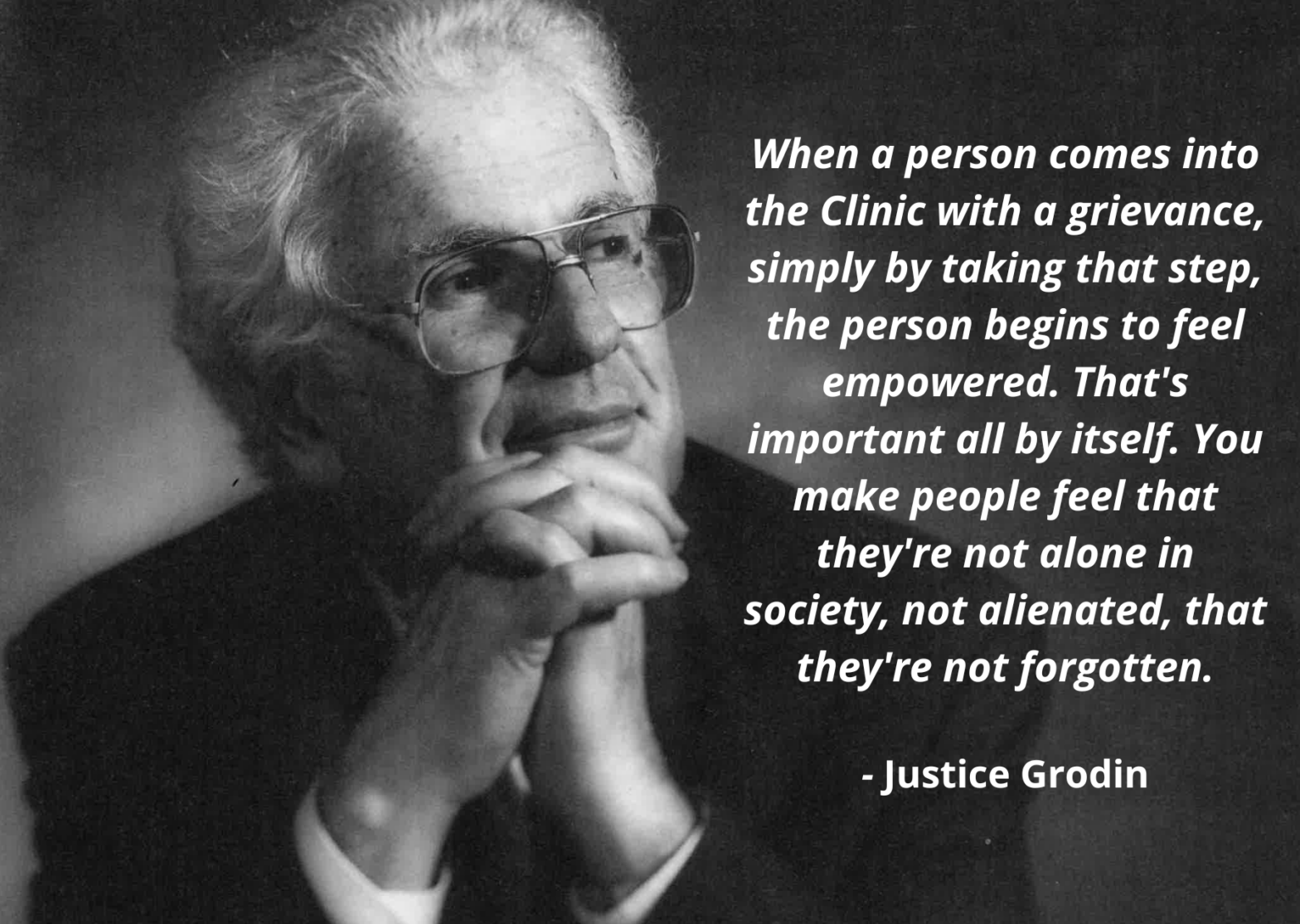 Black and white photo of an older man with white hair and glasses, resting his chin on his hands, next to a quote by Justice Grodin: “When a person comes into the Clinic with a grievance, simply by taking that step, the person begins to feel empowered. That's important all by itself. You make people feel that they're not alone in society, not alienated, that they're not forgotten.”